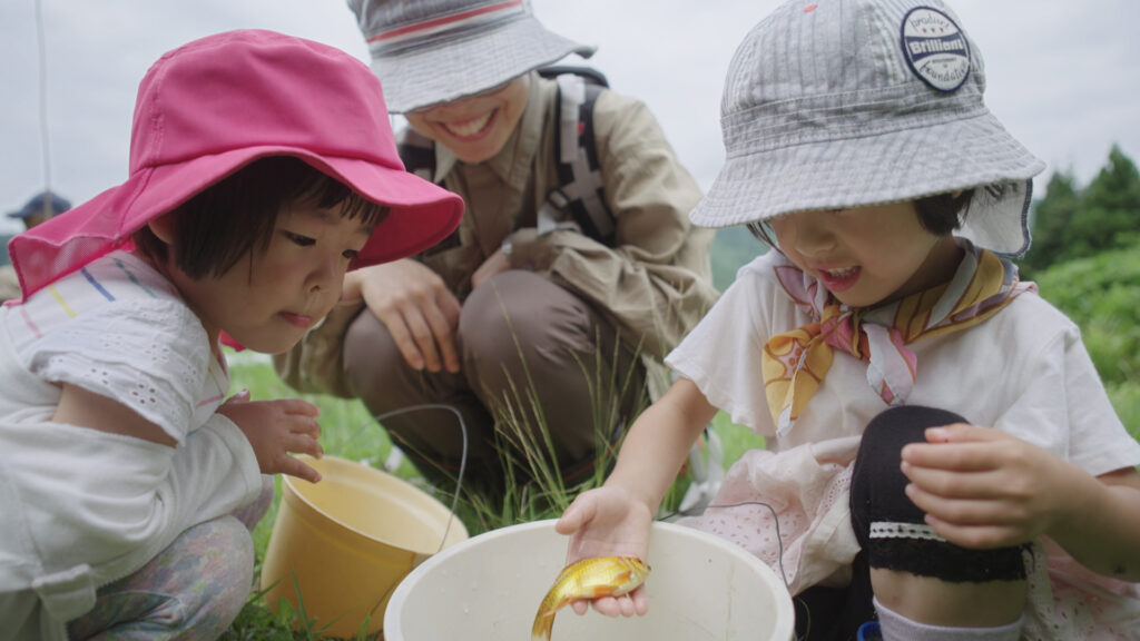 Tamami mit ihren Kindern am Teich von Bauer Yamaga © NZZ Format