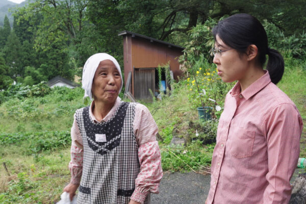 Tatsuko, die mit 70 Jahren jüngste Bäuerin in Ishidani, erklärt Neuankömmling Kanako (re.) die örtliche Pflanzenwelt © NZZ Format